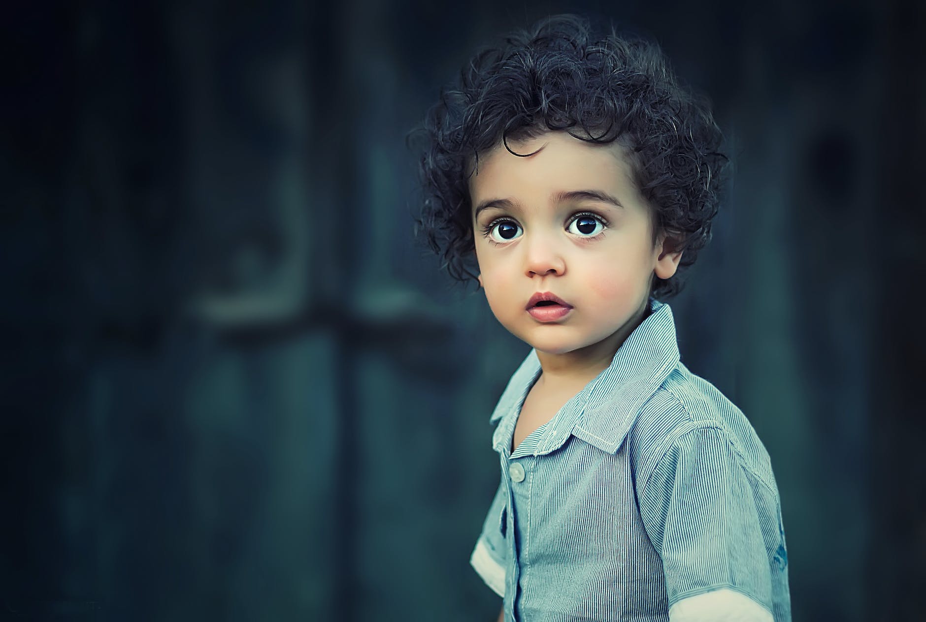 young child stares wide-eyed into the blue-gray distance